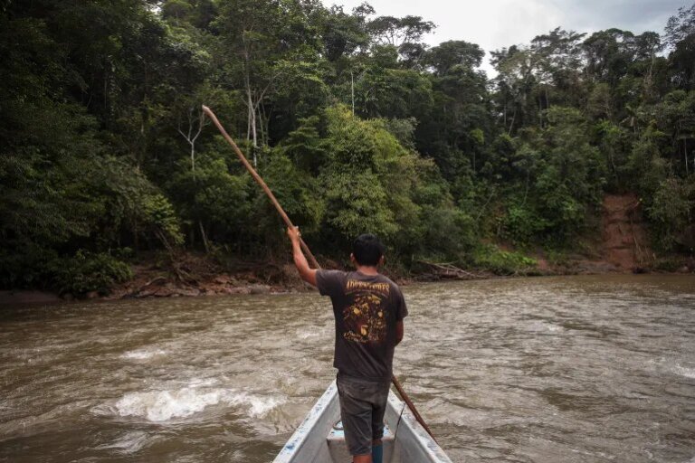 A man from the Waorani of Pastaza Indigenous group navigates the Curaray River in the Amazon province of Pastaza, Ecuador, in April 2022 [File: Fabio Cuttica/Thomson Reuters Foundation]
