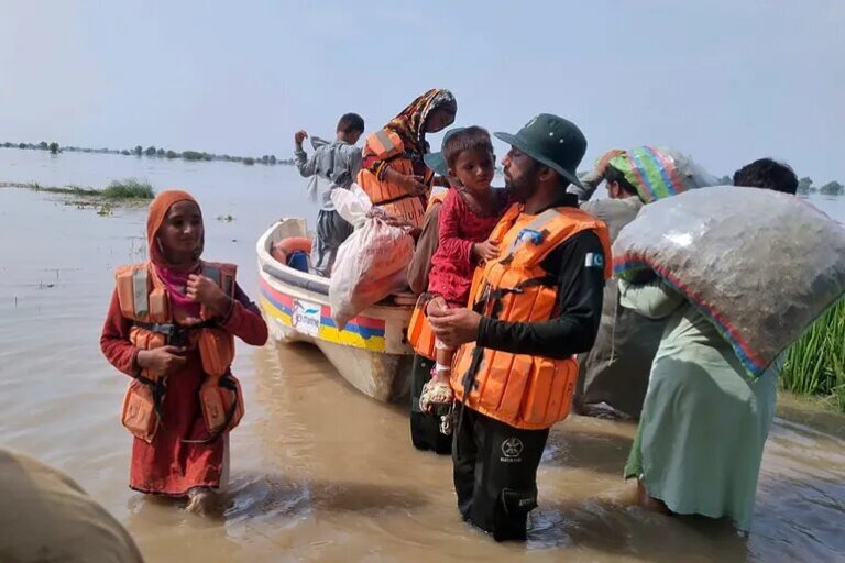 Rescue workers evacuate villagers through a boat from a flooded area of Bahawalnagar district in Pakistan's Punjab province [Rescue 1122 Emergency Department via AP]